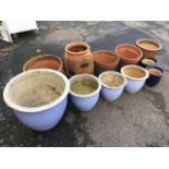 A set of four graduated pale blue glazed stoneware jardinières; four terracotta plant pots; and