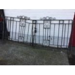 A pair of painted wrought iron garden gates with central scrolled panels and crests, the sides