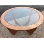 A 60s Wilkins teak G-plan Astro coffee table, the circular plate glass top set into a ring, raised