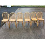 A set of six elm kitchen chairs, the hooped backs with spindles above solid seats. (6)