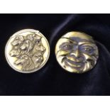 A circular brass vesta case embossed as a happy & sad face, the sprung hinged cover with striking