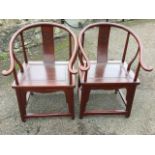 A pair of Chinese armchairs, the rounded crook back rails on shaped tapering supports, having