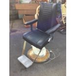 An electric dentists or barbers chair, the adjustable seat with chrome footrest revolving on