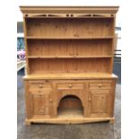 A pine dog-kennel dresser, the delft rack with moulded dentil cornice above a pierced carved apron