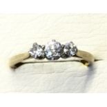 An 18ct platinum diamond ring claw set with three stones on hallmarked band - size K/L.