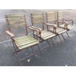 A set of four folding teak garden armchairs, with slatted backs & seats on metal frames, the