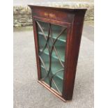 A nineteenth century mahogany corner cupboard with moulded cornice above a plain frieze and an