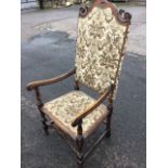 A Queen Anne style walnut armchair with high scroll carved back above an upholstered panel, with