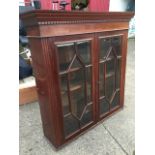 A nineteenth century mahogany glazed bookcase cabinet with moulded dentil cornice above astragel