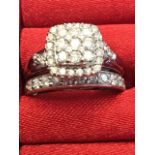 A 9ct gold diamond cluster ring set with square rounded panel of nine diamonds above a similar