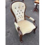 A Victorian style spoonback armchair, the button upholstered back in moulded frame having scroll