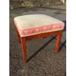 A square nineteenth century upholstered stool, with sprung cushion seat on square tapering legs. (