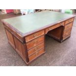 A large mahogany partners desk, the moulded top inset with leather skiver, having wide kneehole with