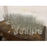A box of two dozen tubular cordial glasses; eighteen American tapering chamfered Duratuff footed