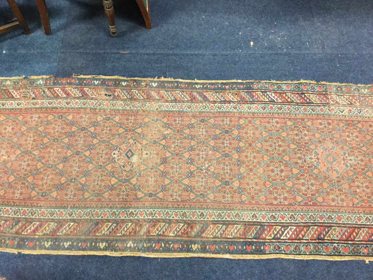 An antique Indian runner, the field woven with two lozenges in floral grid on madder ground, - Image 2 of 3