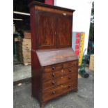 A George III mahogany bureau bookcase, the top with moulded dentil cornice above panelled doors, the