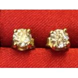 A cased pair of 18ct yellow gold diamond stud earrings, the claw set diamonds weighing in total over