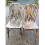 Two wheelback kitchen chairs, the hooped backs on spindles with pierced splats above shaped seats,