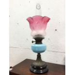 A Victorian brass oil lamp with Aladdin glass chimney framed by acid etched cranberry glass shade,