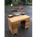 A walnut dressing table with circular scalloped mirror above two small shelves, the kneehole with