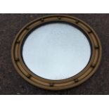 A circular regency style gilt convex mirror, the frame with concave moulding applied with balls,