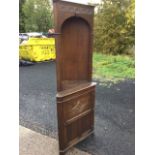 A carved oak corner cabinet, the open top with moulded cornice above a crescent frieze and shaped