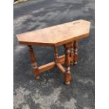 An octagonal walnut turn-over-top card table, having biaze lined interior, raised on baluster turned