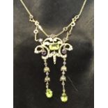 A 9ct gold necklace having central baguette cut peridot in scrolled panel mounted with pearls and