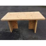 A rectangular pine table with thick plank top on T-shaped supports. (63in x 31.5in x 30in)