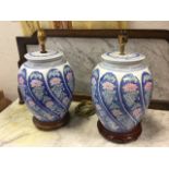 A pair of contemporary chinoiserie tablelamps with pink floral gadrooned moulded jars beneath blue &