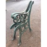 A pair of cast iron bench ends with pierced scrolled decoration raised on channelled sabre legs. (