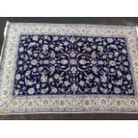 A hand knotted Persian carpet having rectangular blue field entwined with foliage, the frieze of