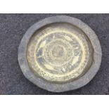 A large antique brass dish, the centre embossed with circular scrolled medallion framed by a