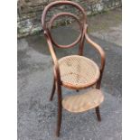 A European childs bentwood high chair, the back with oval panel above a circular cane seat, the