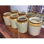 A set of six stoneware salt glazed storage jars with moulded rims; and another similar by Buchan. (