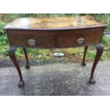 A Georgian style bowfronted mahogany serving table, the top with carved edge above two cockbeaded