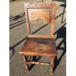 An eighteenth century oak side chair, the back carved with roundels having an arched panel above a