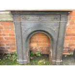 A cast iron fireplace with moulded mantelpiece above a panelled frame with foliate scrolled