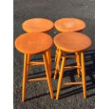 A set of four Swedish Nesto hardwood stools, the circular seats on angled turned tapering legs -