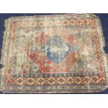 An antique oriental rug woven with blue lozenge medallion on madder flowerhead hexagonal field,
