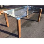 A contemporary plate glass table, the rectangular top on square column legs. (59n x 35.5in x 29.