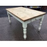 A rectangular pine kitchen table with thick plank top on painted base, the frieze with knobbed