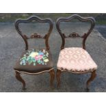 A pair of carved Victorian rosewood chairs with moulded and scalloped shaped backs above pierced and