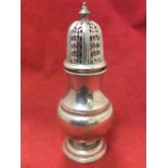 A Georgian style hallmarked silver caster, the pierced hexagonal domed cover with turned finial