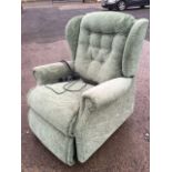 A Sherborne electric reclining button upholstered armchair with integral footstool.