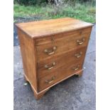 An oak chest of drawers with rectangular moulded top above a brushing slide and three long graduated