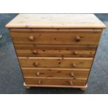 A reproduction pine chest of drawers, the rectangular moulded top above five long knobbed drawers,