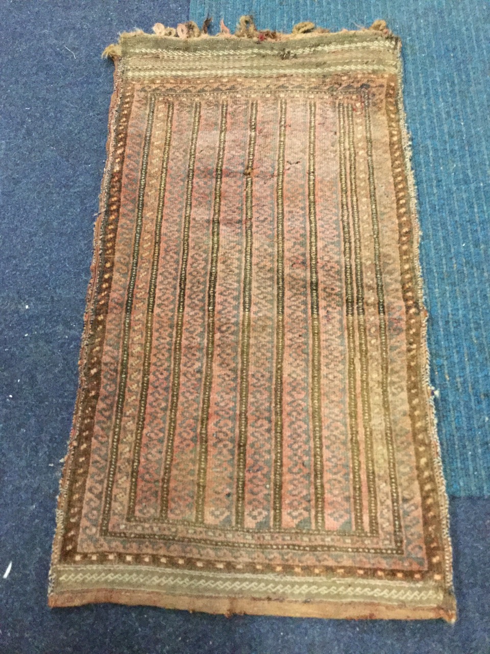 A nineteenth century kelim cushion cover, woven with three bands of hooked square medallions