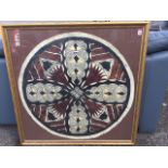 A gilt framed circular handpainted African tribal skin panel with quatrefoil leaf shield type