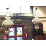 A pair of Victorian style hanging oil lamps, the electric wired lights having ceramic reservoirs